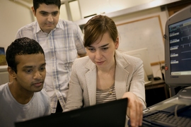 Associate Professor Dina Katabi, right, works with graduate students Shyam Gollakota, left, and Haitham Hassanieh, center.