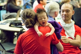 Baby Pau Wang-Levy with his mom Taylor Levy and dad Che-Wei Wang (background, red shirt), two organizers of the hackathon and students at the MIT Media Lab in the Playful Systems Group. 