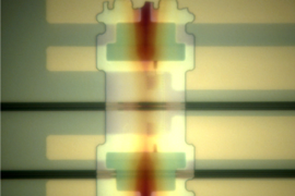 One of the researchers' new photon detectors, deposited athwart a light channel — or "waveguide" (horizontal black band) — on a silicon optical chip.