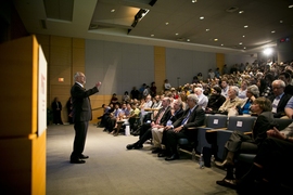 Molina addresses an overflow crowd in Wong Auditorium. 