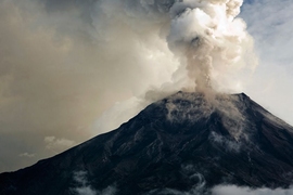 Photo of a volcano erupting with a smoke plume