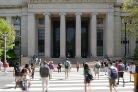 Students cross the street going towards MIT's main entrance