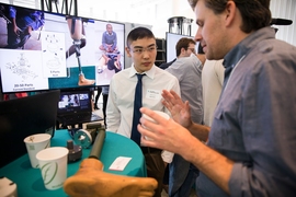 A team member of Need-a-Knee, the $10,000 prize winner, speaks with attendees. Need-a-Knee is developing an inexpensive leg prosthetic that allows users to sit cross-legged. 