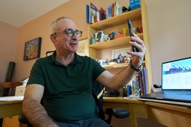 Joshua Angrist sitting at his desk, videochatting on his smartphone