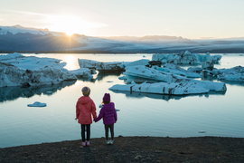 children watching sunset over water