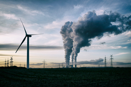 water vapor plumes from power plan behind a wind turbine