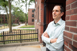 Justin Steil leans against a brick entryway