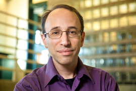 Dan Spielman smiles to the camera in a purple shirt