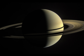 A hi-resolution image shows a titled beige Saturn and its rings on a black background