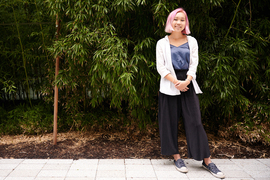 Susan Su stands in a courtyard with tall bamboo in background.