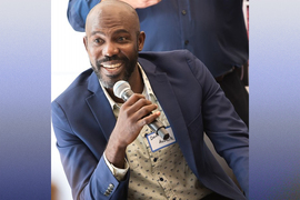 Daniel Auguste portrait while holding a microphone.