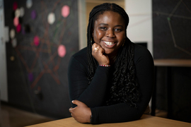 Mercy Oladipo smiles while her hand rests on her chin and she wears her Brass Rat ring.