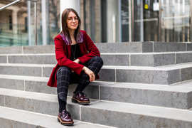 Gazdus sits on the steps of the MIT Media Lab, and her MIT Brass Rat ring is visible.