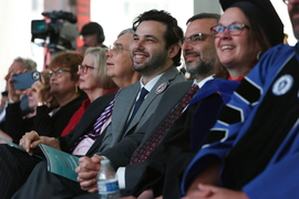 Audience members smile while watching the stage.