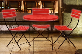 A photo shows a wooden table and wooden chairs that are glowing red, as if highlighted.