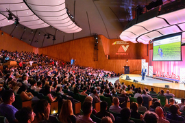 Kresge Hall has a packed audience while a person speaks on stage.