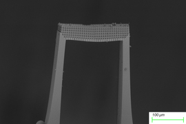 Closeup of the bridge-like metamaterial shows it is made of a honeycomb lattice. An inset shows the bridge is less 100 um thick.