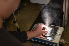 A person manipulates a valve as steam emerges.