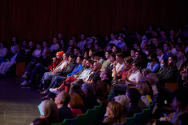 The seats are packed and the audience watches the event.