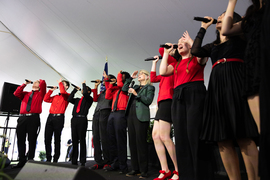 Sally Kornbluth and a group of MIT student singers performing on stage