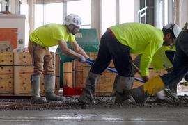 Workers spreading wet cement