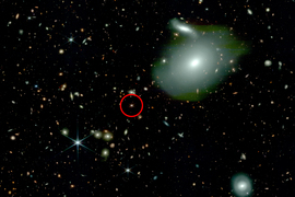 Thousands of galaxies appear as tiny bright lights, and one is circled in red.